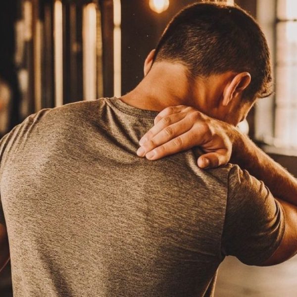 Ragazzo sportivo che sente dolore muscolare in palestra